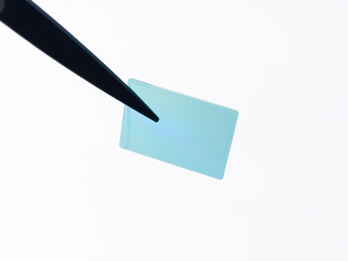 Translucent conductive polymer film held in laboratory tweezers